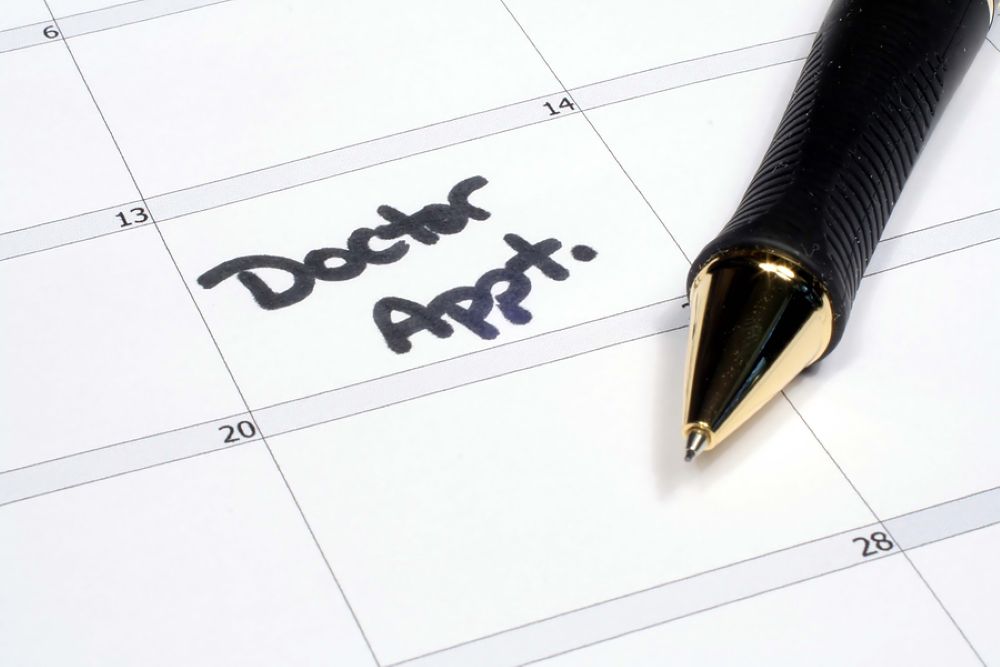 Doctor appointment noted on a calendar with a pen nearby