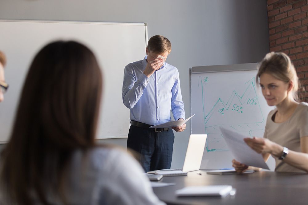 Anxious man unable to complete presentation in meeting room with two women colleagues